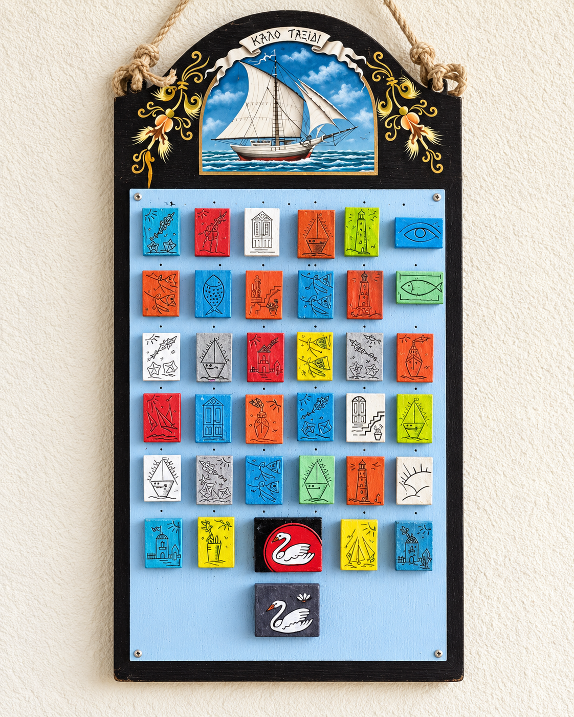 Colorful display of small square decorative artworks and souvenirs arranged in a grid outside a shop in Mykonos, Greece, featuring vibrant blue, red, orange, yellow, and turquoise designs.