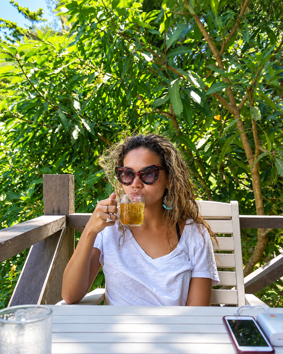 Rosi Ross enjoying a drink surrounded by tropical greenery at Mari Mari Lodge on Mantanani Island, Sabah, Malaysia.