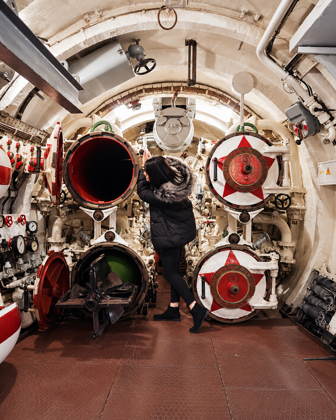 Rosi Ross inside the C-56 Submarine Museum in Vladivostok, exploring its preserved torpedo compartment and naval machinery.