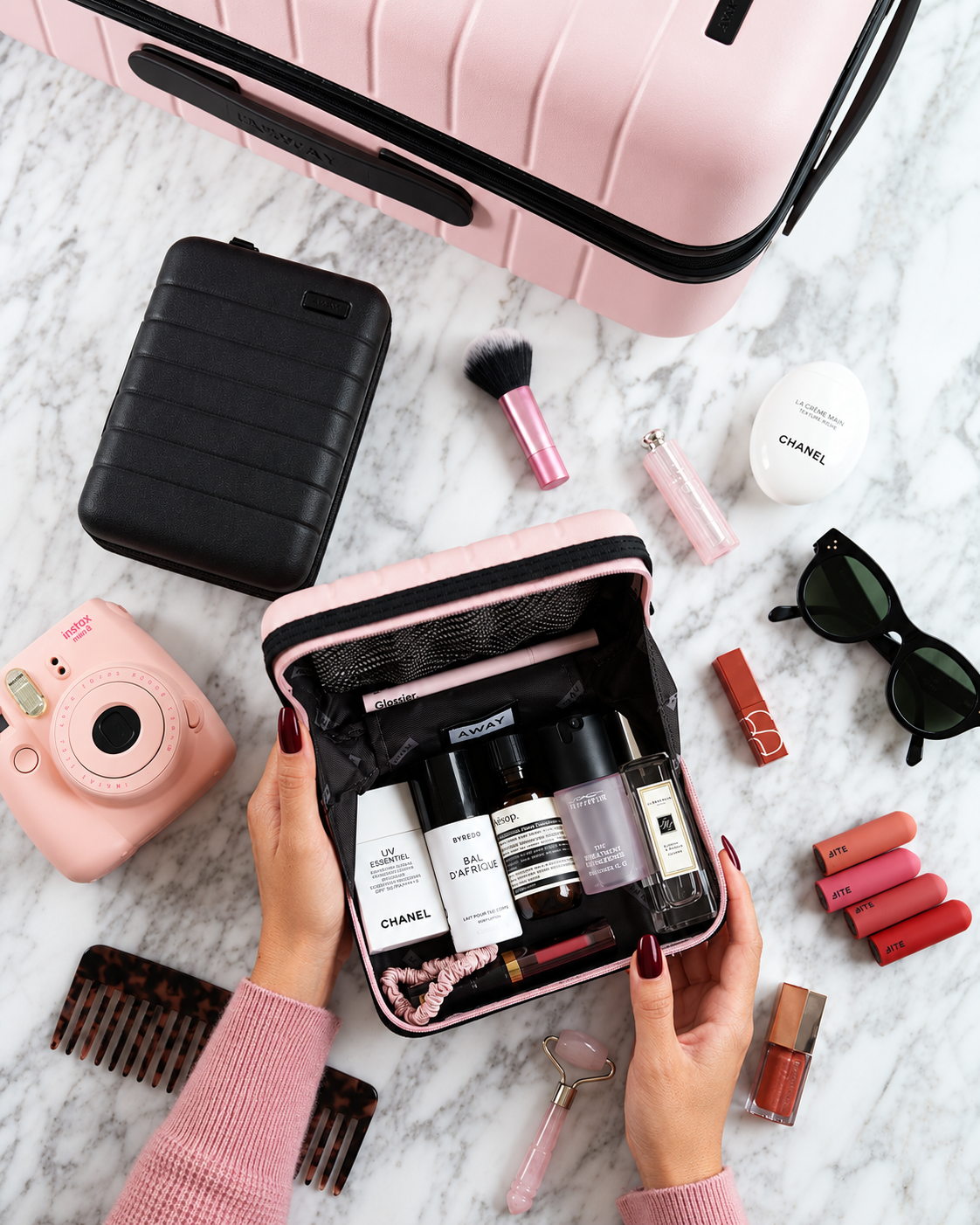 Rosi Ross packing travel beauty essentials, organizing skincare, makeup, and compact products into a practical beauty case for lighter travel.