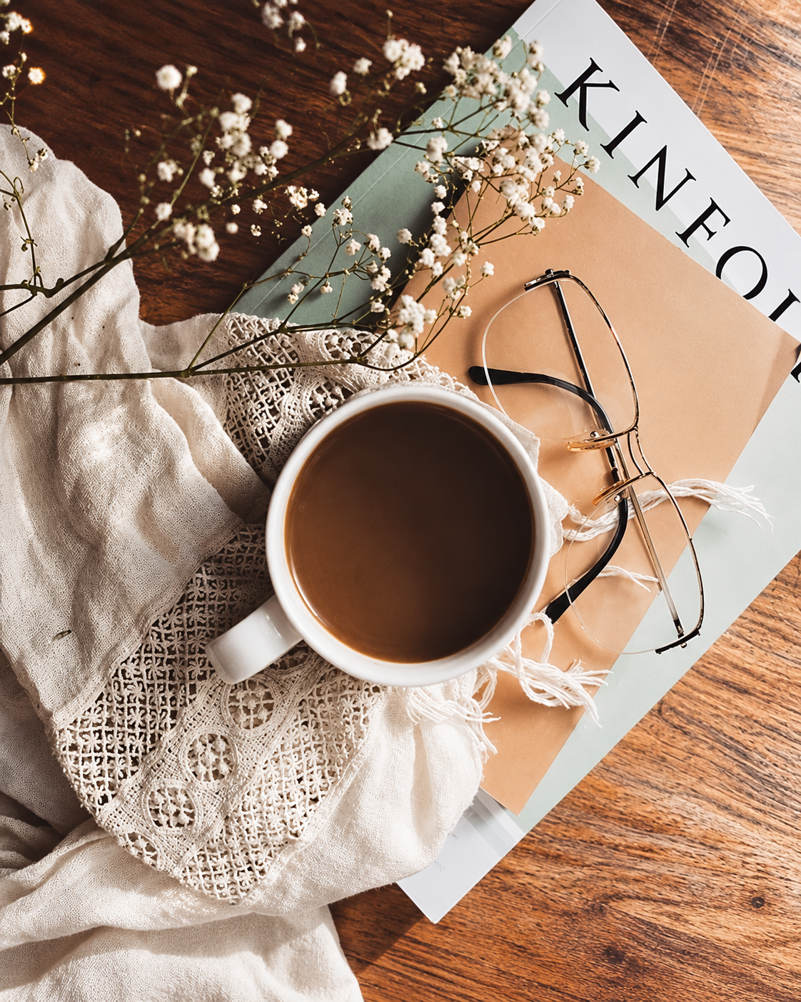 Coffee, eyeglasses, and a fashion magazine arranged for a relaxing reading ritual, reflecting Rosi Ross&rsquo;s interest in fashion, creativity, and mindful living.