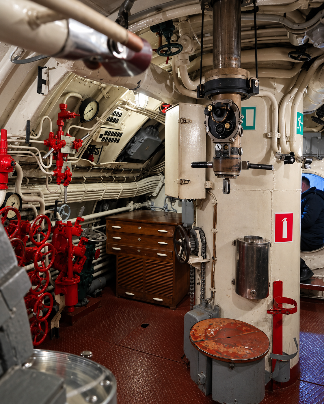 Control room inside the historic C-56 submarine in Vladivostok, featuring preserved naval equipment, pipes, valves, and instrumentation.