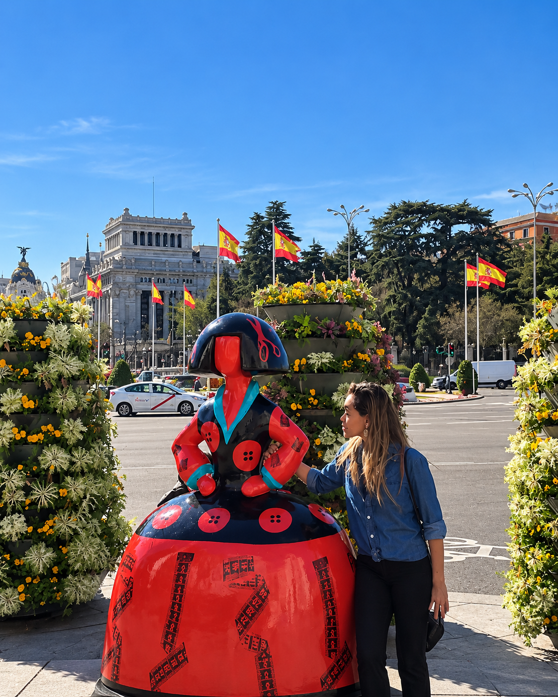Rosi Ross exploring Plaza de Cibeles in Madrid with the historic city landmarks in the background.