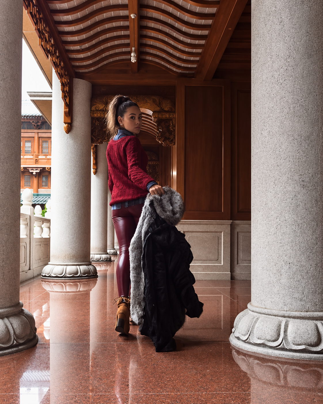 Rosi Ross wearing a burgundy winter outfit inside a traditional Shanghai interior, blending personal style with Chinese architecture and culture.