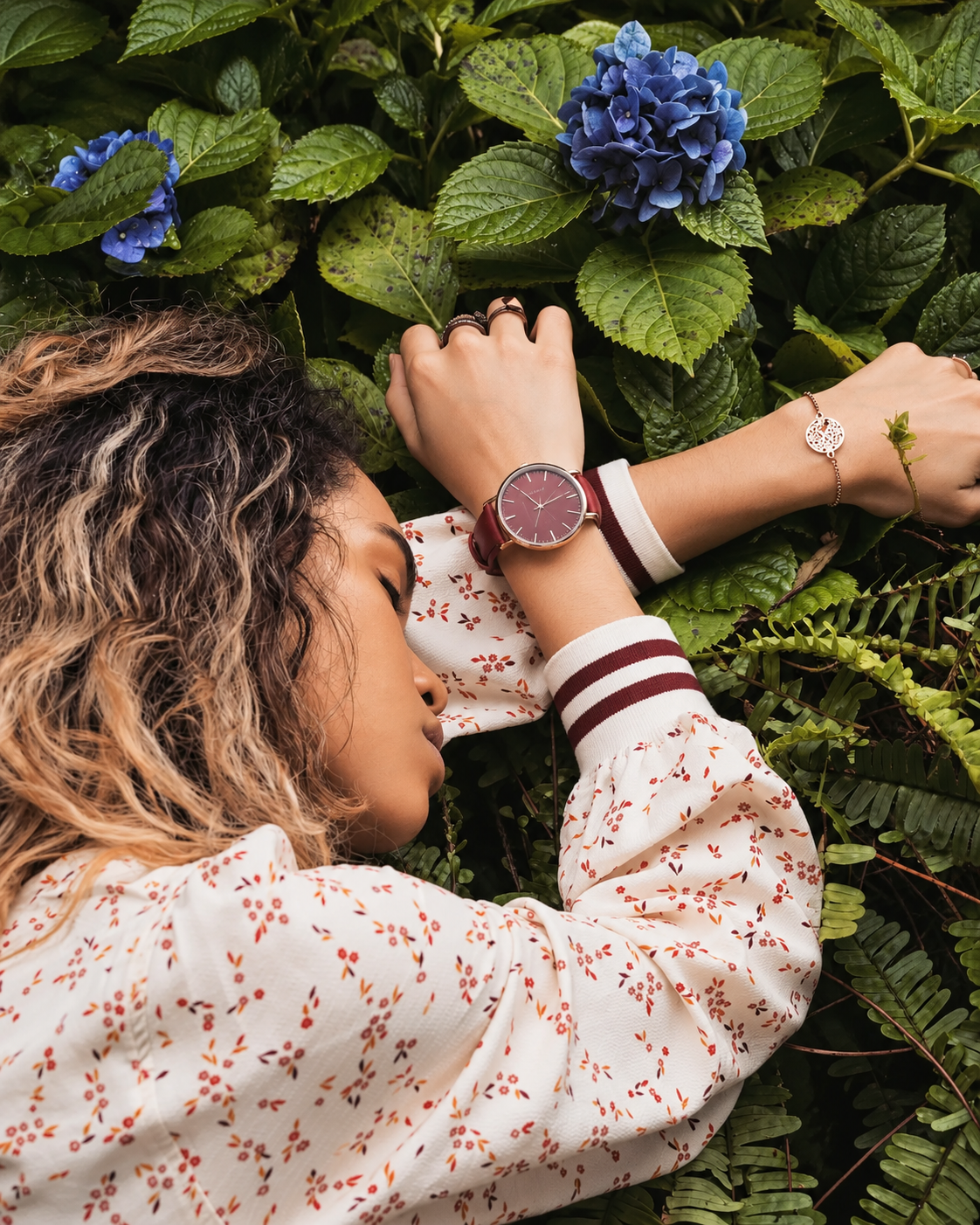 Rosi Ross wearing a Theodoras watch from the Leather Collection, featuring a burgundy dial and matching leather strap in a nature-inspired fashion editorial.