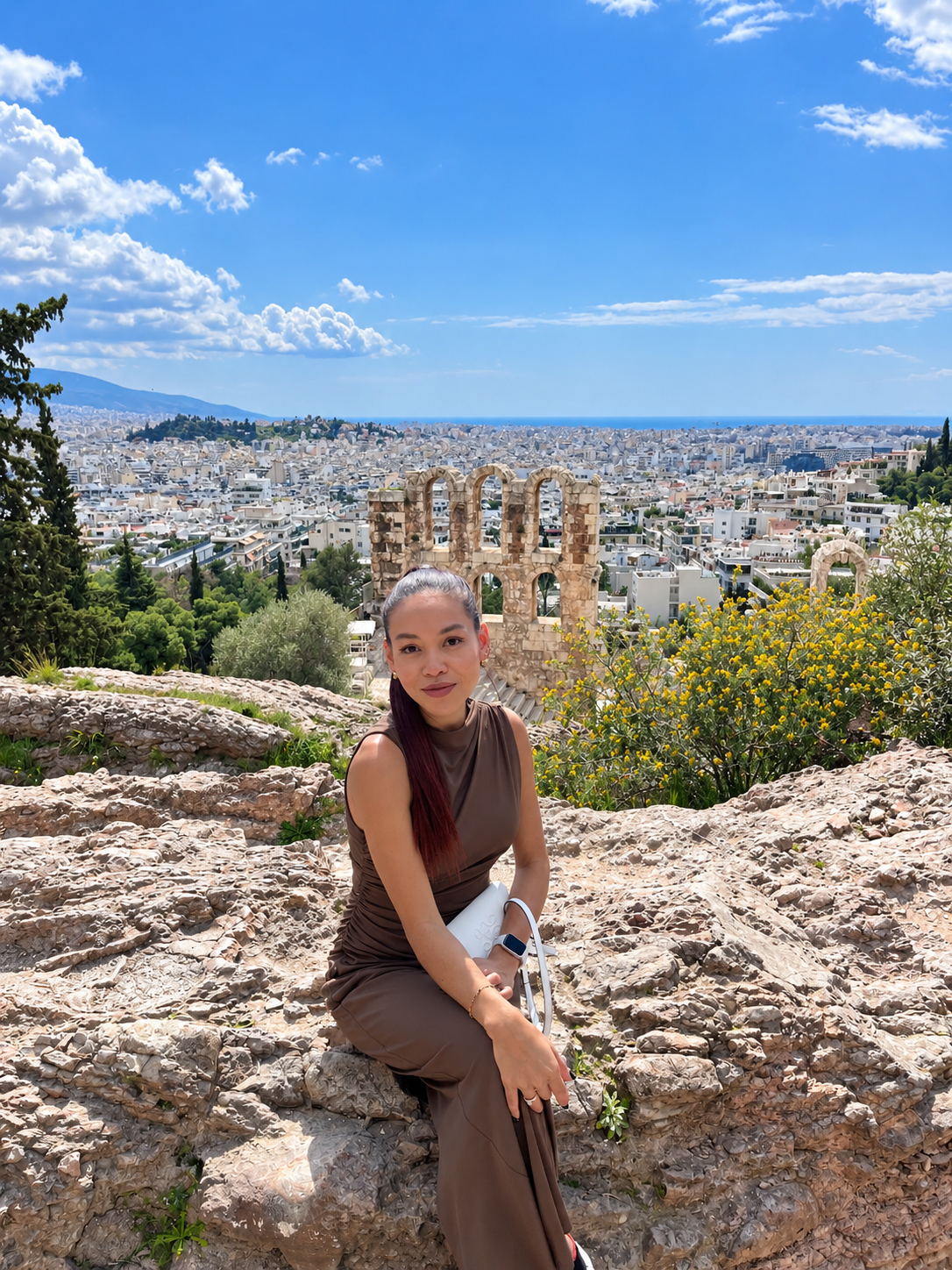 Rosi Ross at the Acropolis of Athens overlooking the panoramic cityscape of the Greek capital.