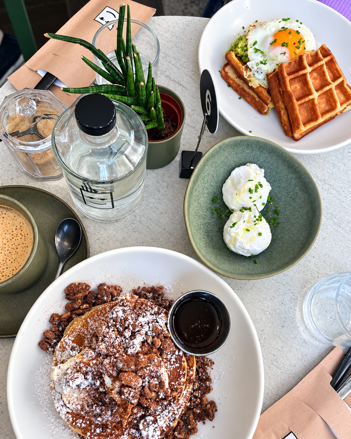 Brunch spread at The Makers Athens featuring coffee, waffles, eggs, and contemporary breakfast dishes.