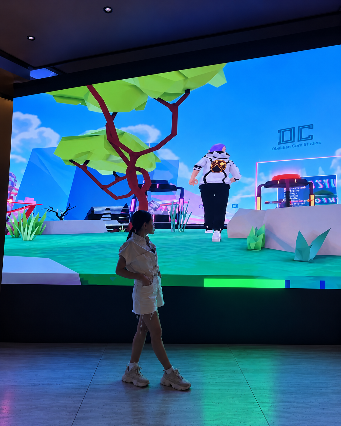 Rosi Ross exploring a virtual world and immersive technology event featuring digital characters, interactive screens, and gaming experiences.