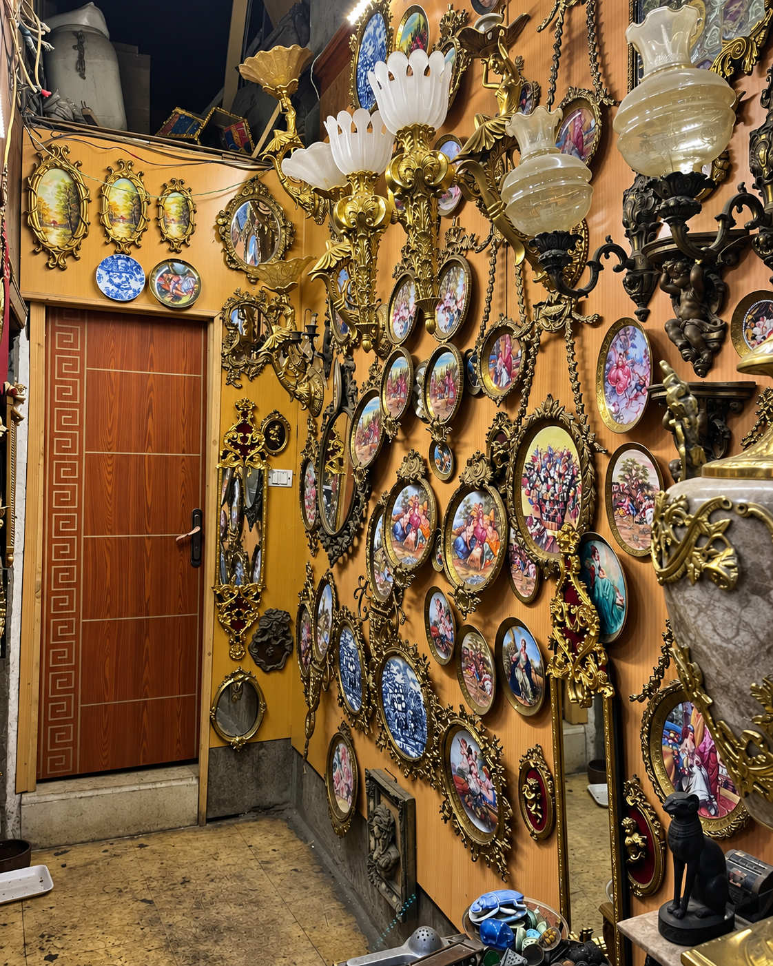 Decorated Wall with Vintage Decor at Al Khalili Cairo Market Decorated wall with vintage plates, ornate mirrors, and antique sconces at Al Khalili