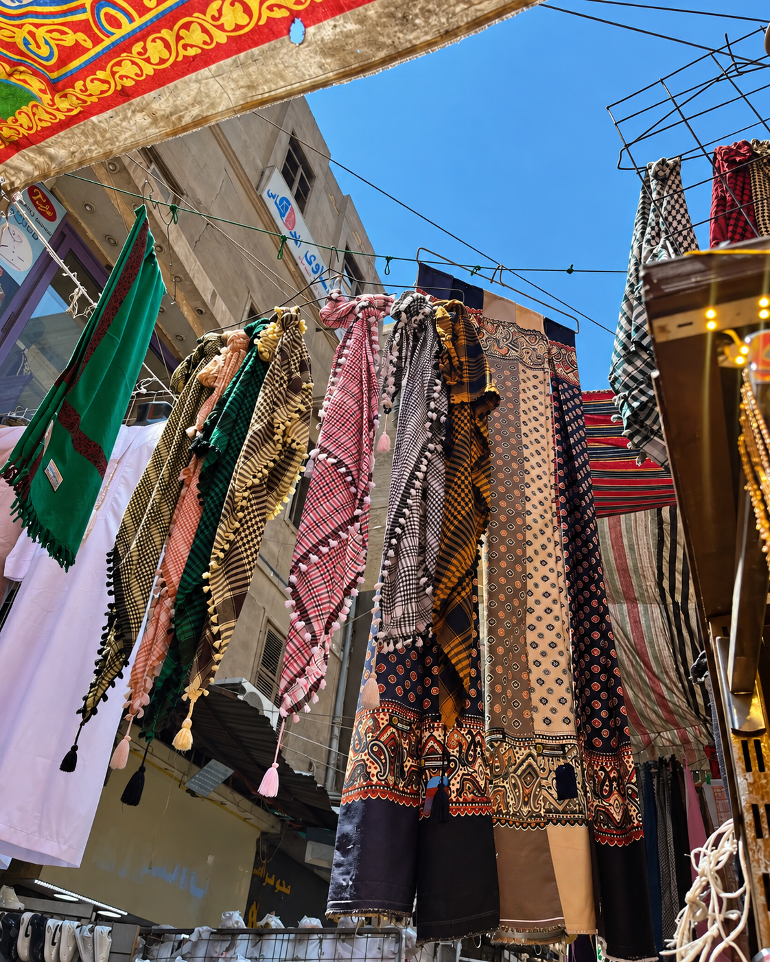 Colorful Fabrics in Market at Al Khalili Cairo Market Colorful fabrics hanging in a market under a clear blue sky at Al Khalili