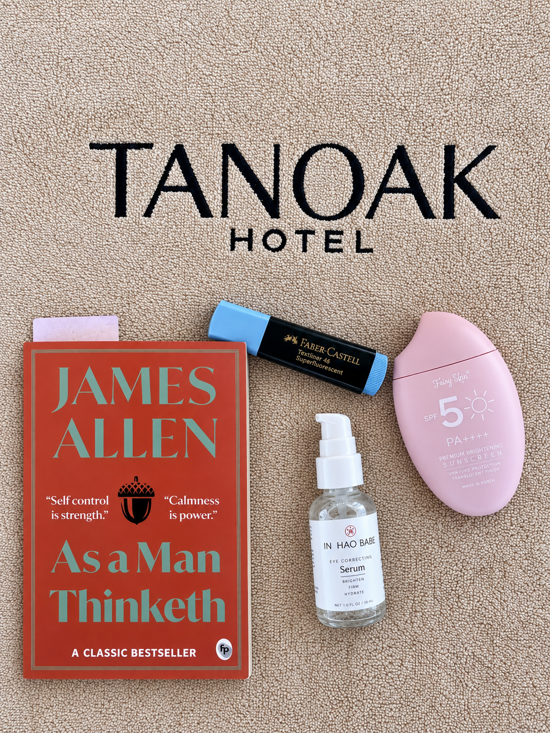 Book and Beauty Products on Hotel Towel at Tanoak Resort in Ain Sokhna Open book on hotel towel with cosmetics and sunscreen at Tanoak Resort in Ain Sokhna