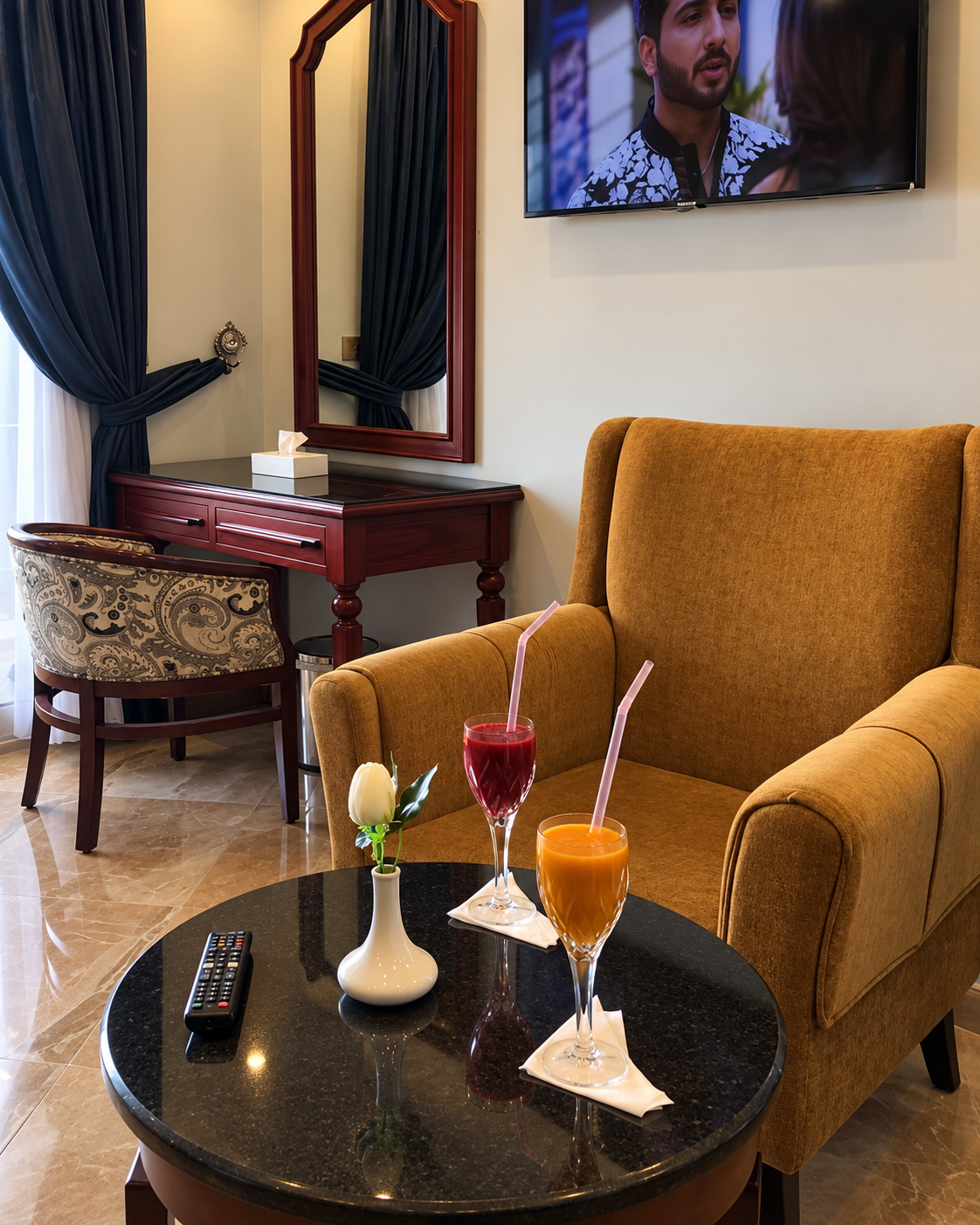 Delights at Nile Heaven Cairo Luxury hotel room with armchair, drinks, and TV from Nile Heaven Cairo