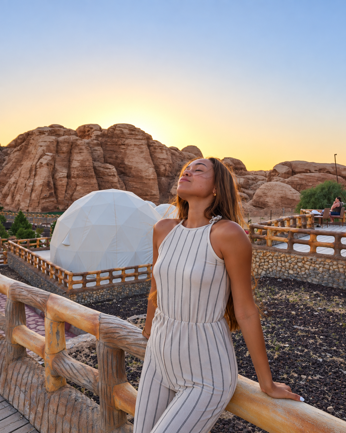 Woman Posing at Sunset at Seven Wonders Luxury Camp Petra Woman in striped jumpsuit at sunset near dome structure and rocky landscape at Seven Wonders Luxury Camp Petra
