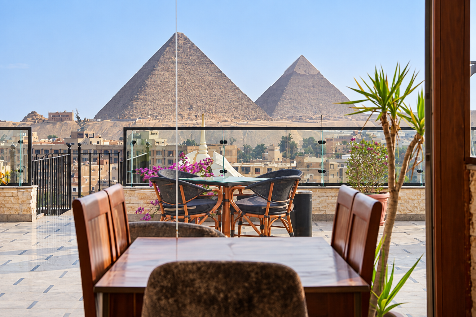 Pyramids View from Rooftop Cafe from Pyramids Inn Cairo View of the Pyramids of Giza from a modern rooftop cafe with wooden furniture and plants from Pyramids Inn Cairo