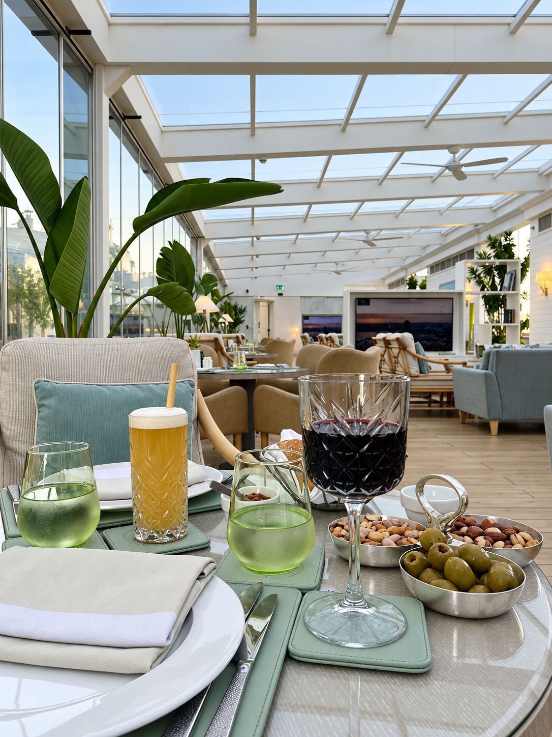 Elegant restaurant table setting with drinks and snacks in a modern glass-enclosed room at the Four Seasons Cairo