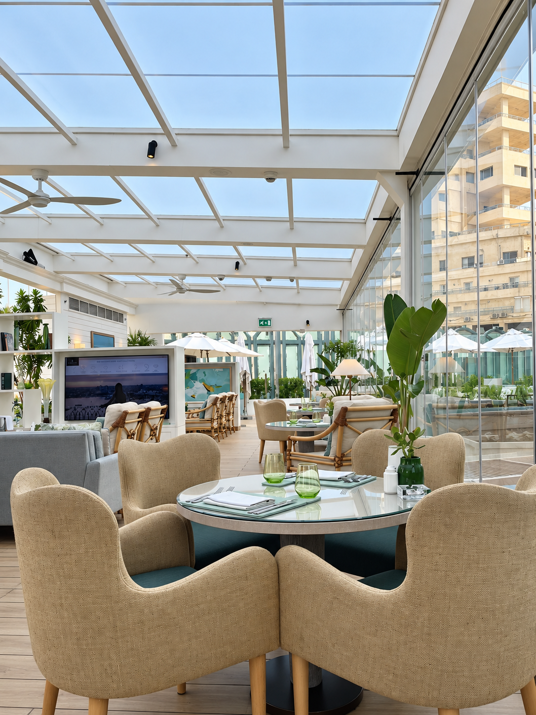 Elegant indoor cafe seating with large glass windows and sleek furniture at the Four Seasons Cairo