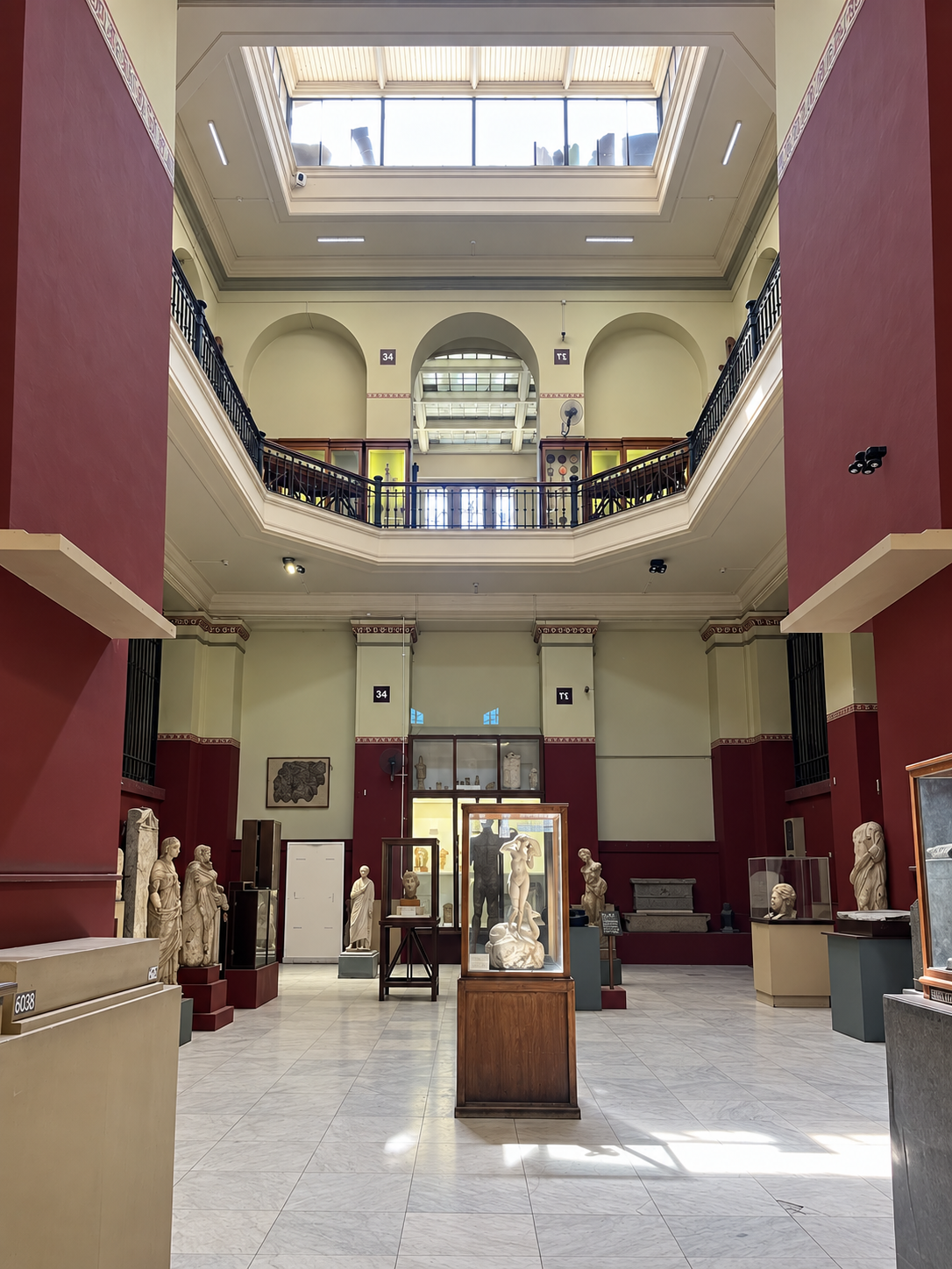 Museum Interior with Atrium and Statues at the National Museum of Egyptian Civilization in Cairo Interior view of a museum hall with a large open atrium, skylight, and ancient statues displayed on the ground floor at the National Museum of Egyptian Civilization in Cairo