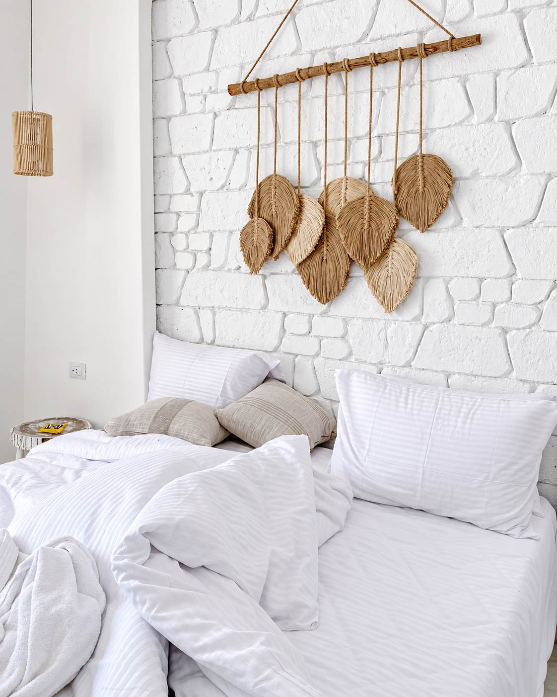 Minimalist bedroom with white bedding and leaf wall decor at Tanoak Resort in Ain Sokhna