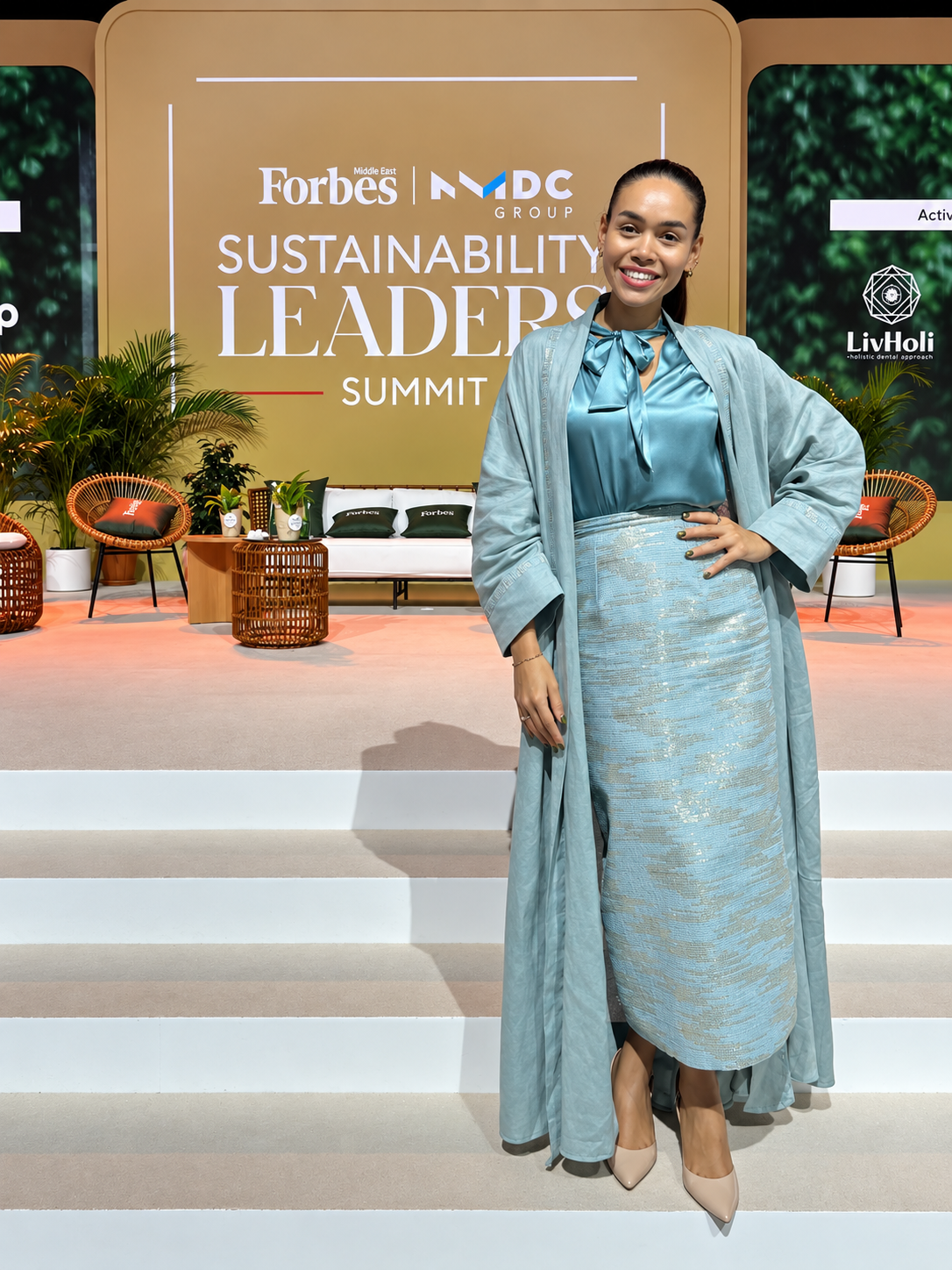 Rosi Ross at Forbes Middle East Sustainability Leaders Summit Rosi Ross in light blue dress with long jacket from BellaDonna Atelier at Forbes Middle East Sustainability Leaders Summit stage