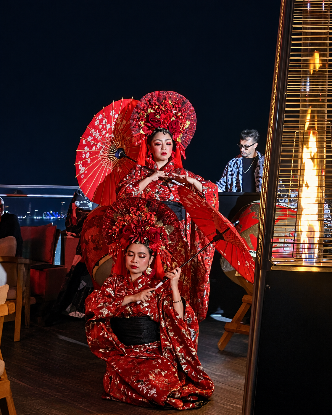 Traditional Red Costume Performance Art at ATTIKO Dubai Two performers in vibrant red traditional costumes with ornate parasols during nighttime cultural performance at ATTIKO Dubai