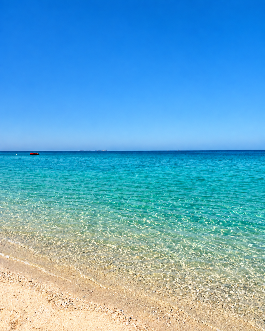 Clear Turquoise Water Beach at Nikki Beach Dubai Clear turquoise water gently laps against a sandy beach under a bright blue sky, with a few people swimming in the distance at Nikki Beach Dubai
