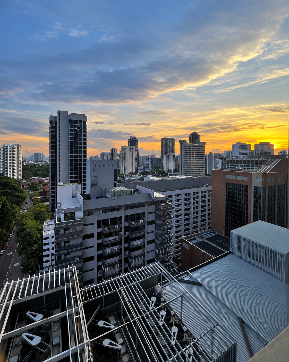 Urban cityscape at sunset with downtown high-rise buildings and residential towers under golden and blue sky